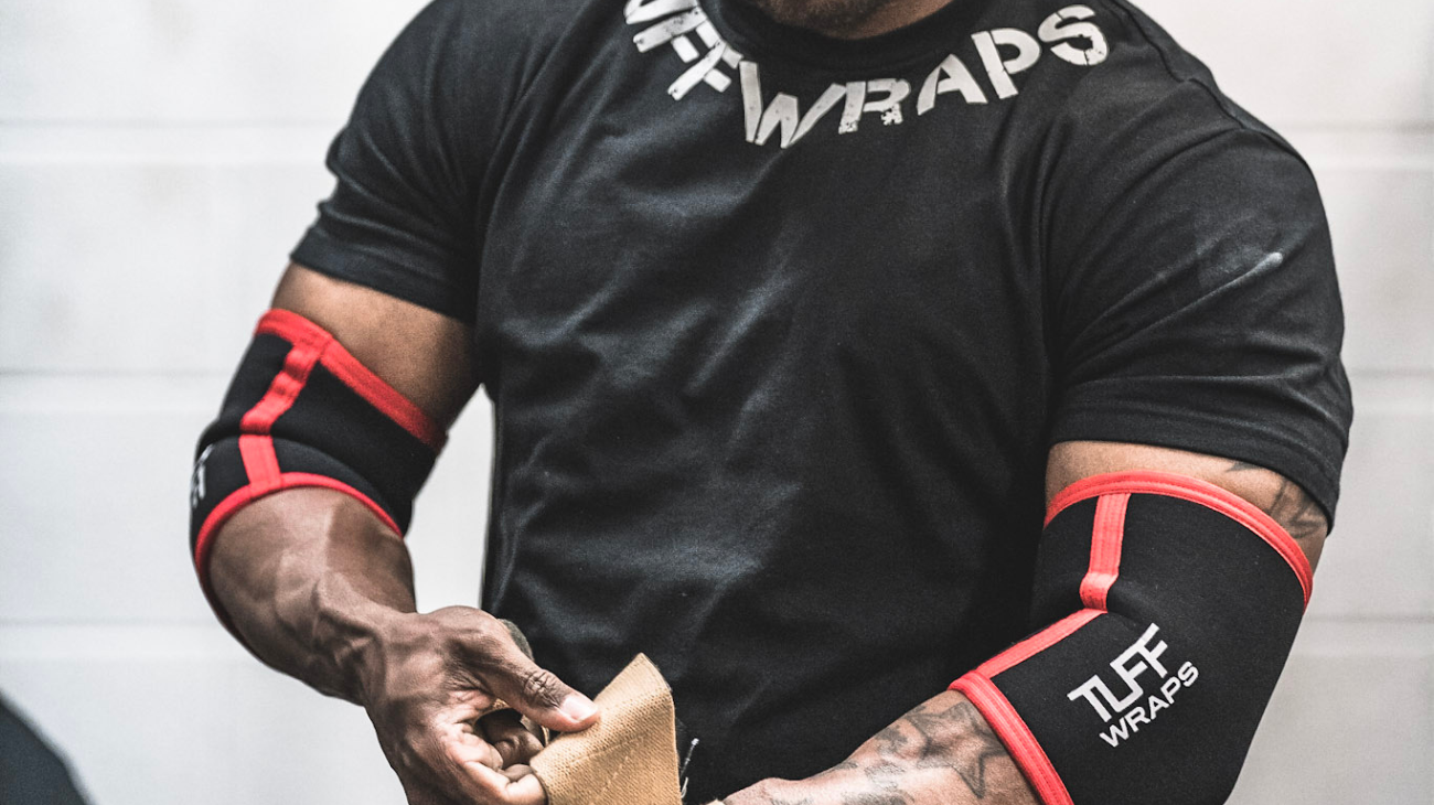 man putting on elbow wraps before bench press