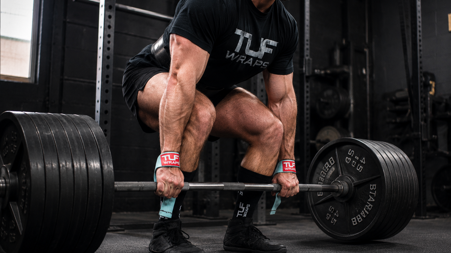 Lifter using a hook grip on a loaded barbell for a heavy deadlift