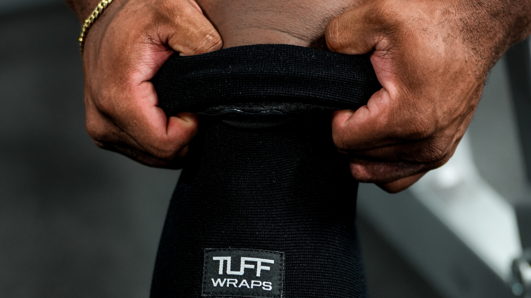 man putting on knee sleeves for deadlift