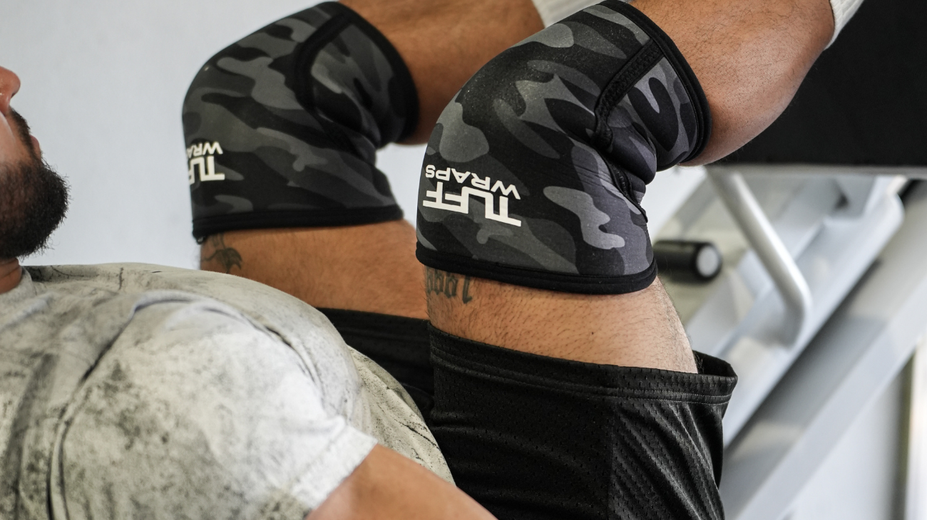 man using knee wraps for leg press