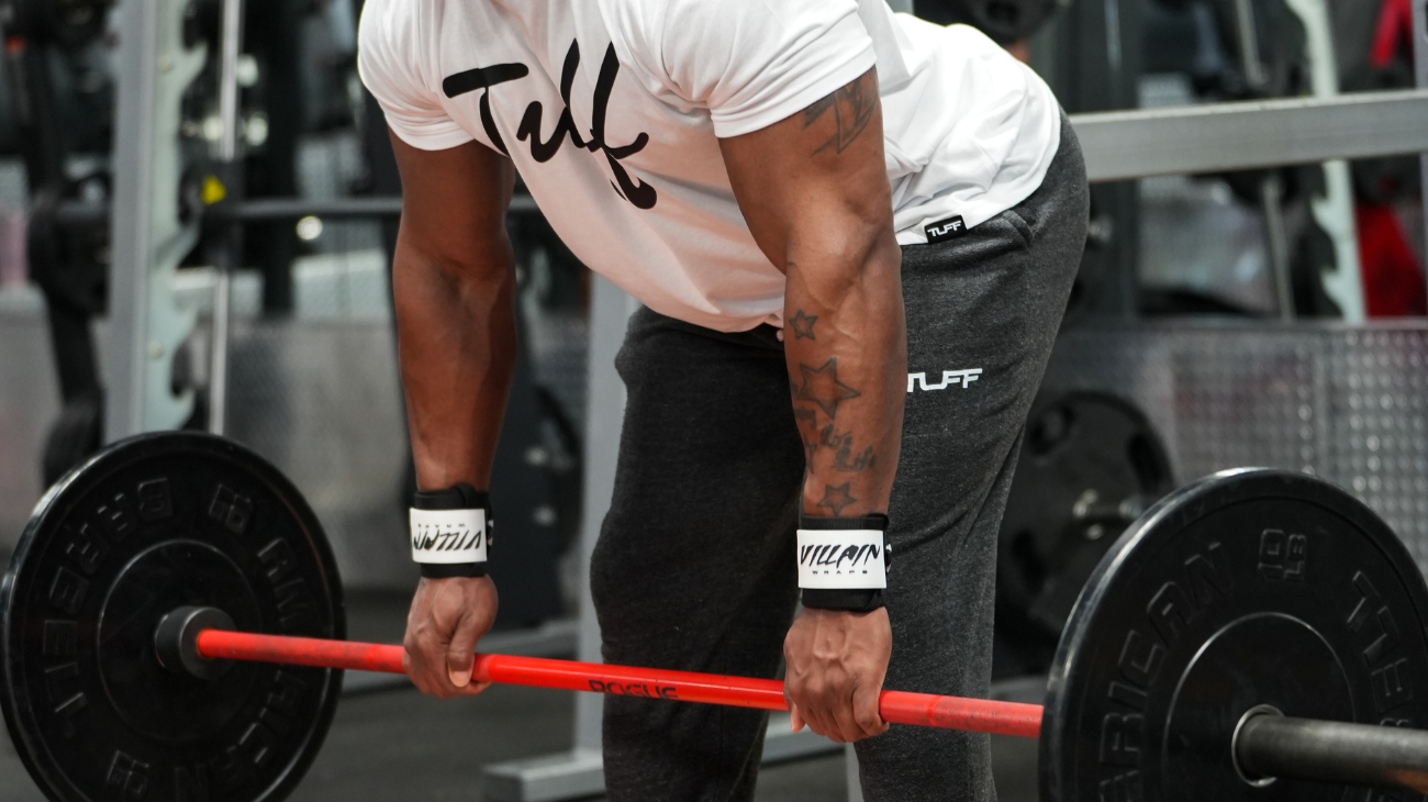 trainer deadlifting with a lifting belt