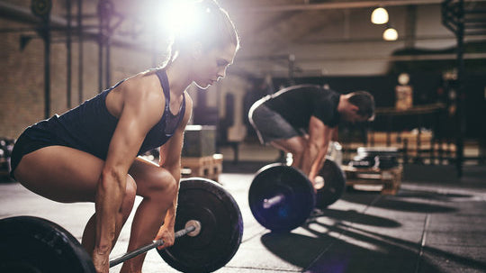 woman performing deadlifts vs rack pulls