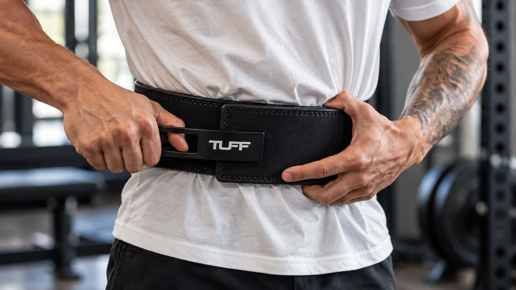 Lifter rolling a leather belt to show how to break in a lifting belt safely