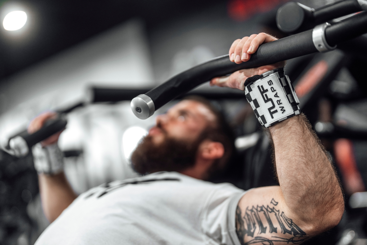 Lifter wearing wrist wraps grips a barbell during bench press to avoid wrist pain