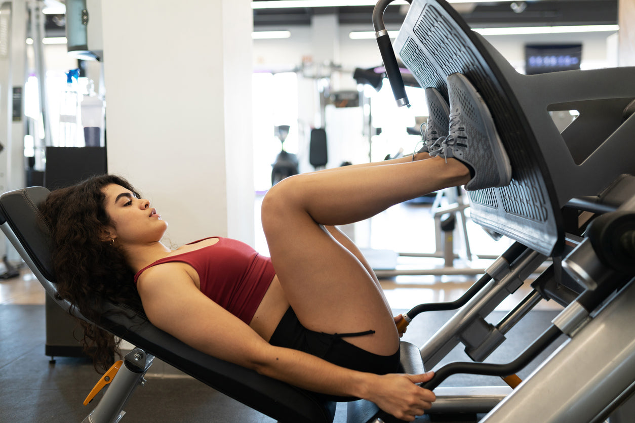 trainer using leg press machine