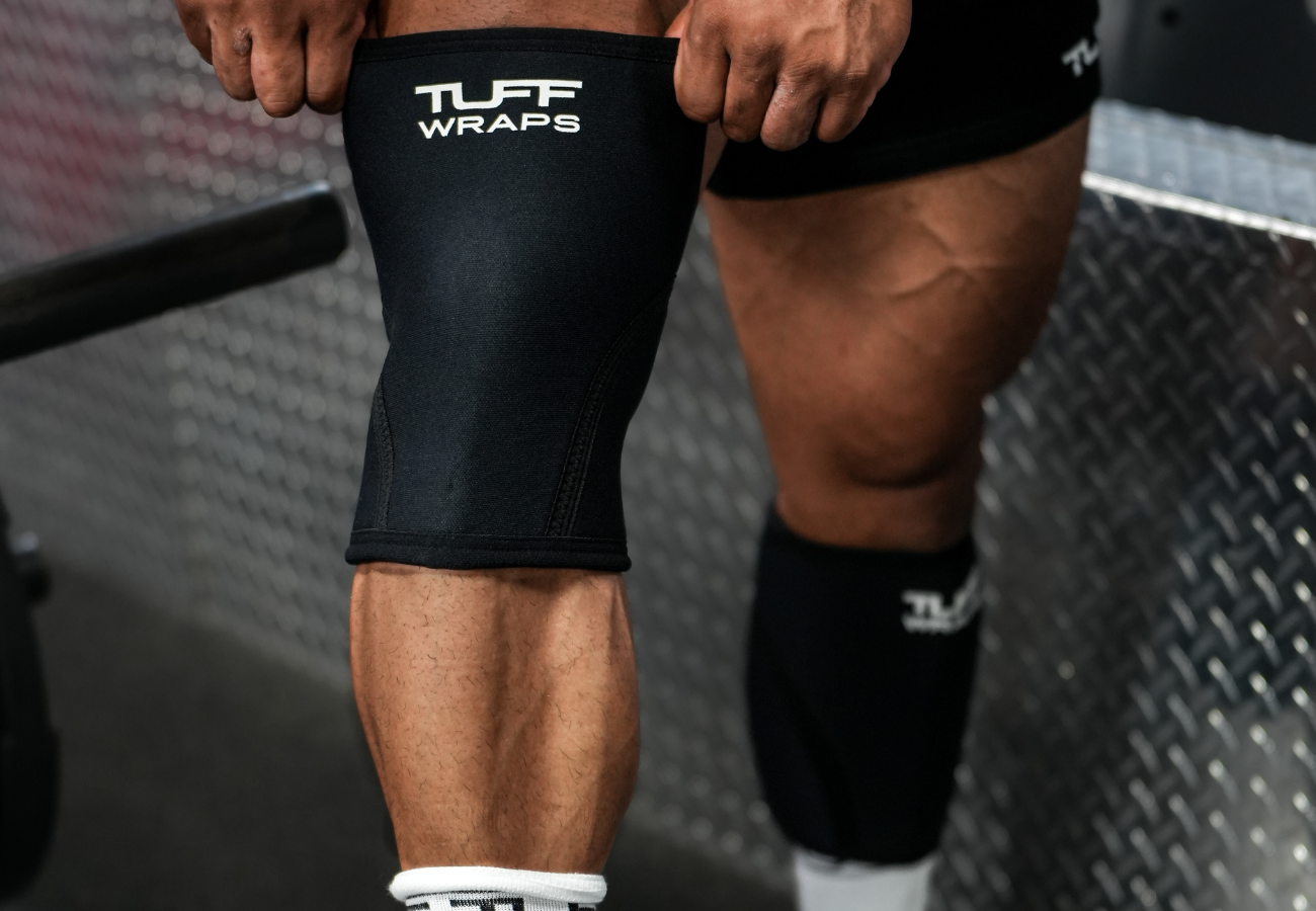 man putting on tuff knee sleeves