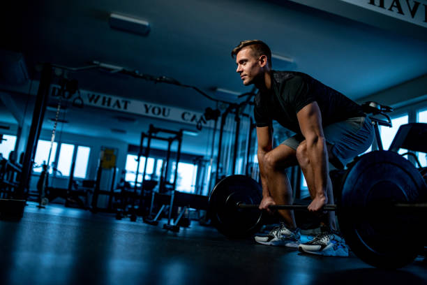 trainer preparing to do stiff leg deadlift