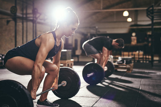 woman performing deadlifts vs rack pulls